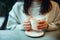 Young woman in warm sweater holding cup of coffee and planing personal goals for new year.