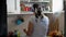 Young woman washes the dishes listening to music with headphones