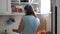 Young woman washes the dishes listening to music with headphones