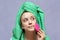 Young woman washing face with silicone pink brush and cleansing foam. Cosmetic products