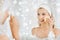 Young woman washing face with sponge at bathroom