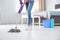 Young woman washing floor with mop in bedroom, closeup
