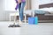Young woman washing floor with mop in bedroom, closeup.
