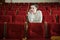 Young woman watch show in empty theater or cinema hall