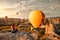 Young woman watches and photographs flying colorful balloons on an early morning in Goreme Valley, Cappadocia. Turkey