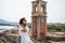 Young woman watching view on Famous touristic landmark old venetian fortress with clock tower, Kerkyra city, Corfu, Greece, summer