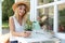 Young woman watering home plant at white wooden table