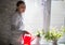 Young woman watering indoor flowers