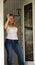 Young woman waving at front door