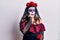 Young woman wearing day of the dead costume over white looking stressed and nervous with hands on mouth biting nails