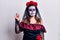 Young woman wearing day of the dead costume over white showing and pointing up with fingers number four while smiling confident