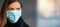 Young woman wearing disposable blue virus face mouth nose mask, closeup portrait, banner with space for text right side.