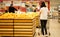 Young woman wearing disposable medical mask shopping in supermarket during coronavirus pneumonia outbreak.