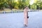 Young woman wearing dress standing outside with camera.