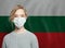 Young woman wearing a face mask with national flag Bulgaria.  Flu epidemic and virus protection concept