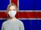 Young woman wearing a face mask with national flag Iceland. Flu epidemic and virus protection concept