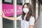 A young woman is wearing face mask for protection covid-19 standing in front of Salon shop, salon safety concept