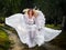 Young woman wearing long white dress and angel wings