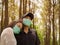 Young woman  and wearing medical face mask a public park a couple Wearing Protective Mask in warm outdoor winter time. new normal