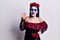 Young woman wearing mexican day of the dead makeup showing and pointing up with fingers number four while smiling confident and