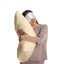 Young woman wearing pajamas and mask with pillow in sleepwalking state on white background