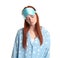 Young woman wearing pajamas and mask in sleepwalking state on white background