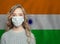 Young woman wearing a protective mask with national indian flag. Flu epidemic and virus protection concept