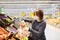 Young woman wearing protective medical face mask shopping in supermarket during coronavirus pneumonia outbreak