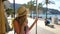 A young woman wearing straw hat enjoying traveling on an old tram or train along sea coast