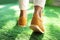 Young woman wearing stylish sneakers on grass, closeup