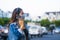 Young woman wearing surgical mask on street while using mobile phone. Portrait of young woman wearing a protective mask to prevent