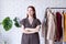 young woman wearing trendy outfit, standing near clothes rack. Wardrobe change