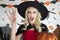 Young woman wearing vampire cloth holding a Halloween pumpkin and making a scary face