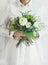 Young woman wearing white clothes holding bouquet. Flower shop concept