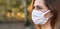 Young woman wearing white home made cotton virus mouth nose mask, nice bokeh in background, closeup face portrait, empty space for