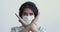 Young woman wears medical face mask showing stop hand gesture