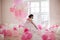 Young woman in wedding dress in luxury interior with a mass of pink and white balloons. Hold in hands her white shoes
