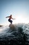 Young woman in a wetsuit on surfboard rides the wave.