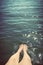 Young woman wetting her legs in the sea. Summer holidays. Vintage.