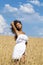 Young woman in a wheat golden field