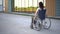 Young woman in a wheelchair. A girl rides in a wheelchair against the background of a glass building. Special transport