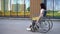 Young woman in a wheelchair. A girl rides in a wheelchair against the background of a glass building. Special transport