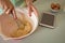 Young woman whisking mixture into bowl in the kitchen