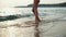 Young woman in white bikini is walking on a beach