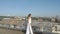 A young woman in white clothes, walking along the tourist observation platform. Beautiful panorama of the city.