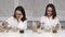 A young woman in a white coat is eating cereal and drinking coffee, sleepy and cheerful. Collage of two screens as a
