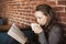 Young Woman with White Coffee Cup Reads Her Bible