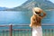 Young woman in white dress and hat looking blue water of lake and mountains on background