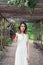 Young woman in white dress holding hawk bird outdoor