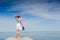 Young woman in white dress sunbathing at the seaside